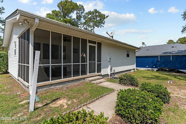 rear view of house featuring a ceiling fan and a sunroom