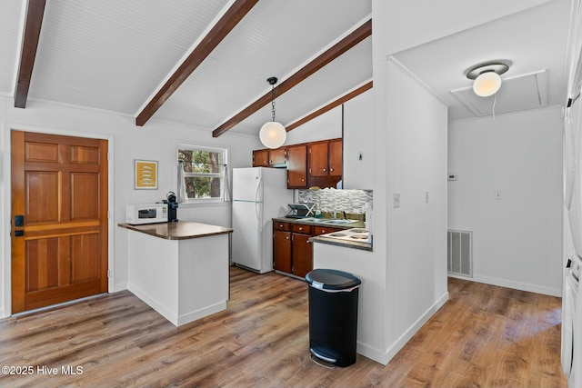 kitchen with visible vents, backsplash, white appliances, dark countertops, and wood finished floors