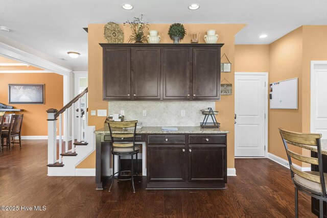 interior space with tasteful backsplash, dark wood-style floors, and baseboards