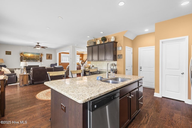 kitchen featuring dishwasher, a sink, ceiling fan, an island with sink, and dark wood-style floors