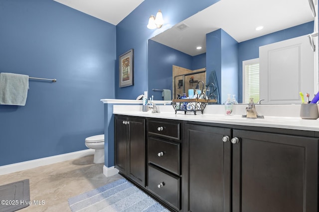bathroom with baseboards, double vanity, toilet, a shower stall, and visible vents