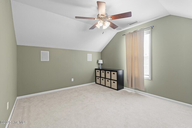 additional living space featuring visible vents, ceiling fan, carpet, and vaulted ceiling