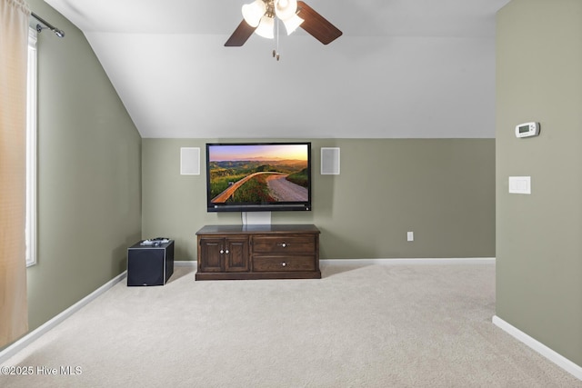 carpeted living room with ceiling fan, baseboards, and lofted ceiling