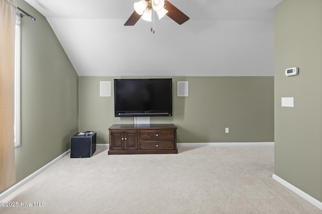 living room featuring carpet floors, baseboards, a ceiling fan, and lofted ceiling