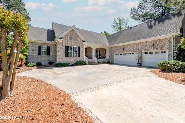 view of front of property with roof with shingles, driveway, a garage, and brick siding