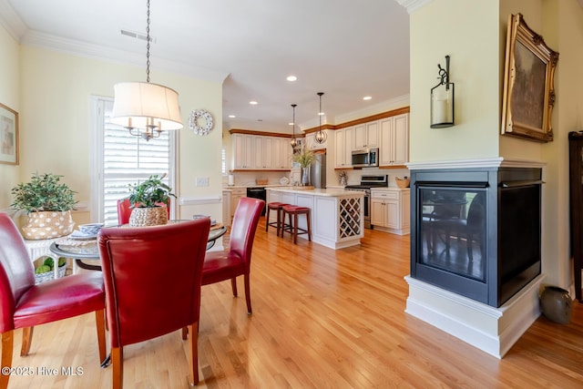 dining space with ornamental molding, visible vents, recessed lighting, light wood finished floors, and a notable chandelier