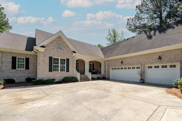 single story home featuring concrete driveway, roof with shingles, a garage, and brick siding