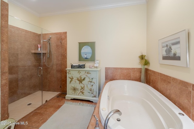 bathroom featuring a stall shower, a garden tub, ornamental molding, and tile patterned flooring