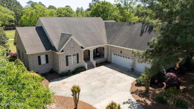view of front of home featuring crawl space, roof with shingles, brick siding, an attached garage, and concrete driveway