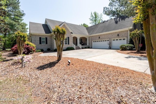 traditional-style house with a garage, concrete driveway, and brick siding