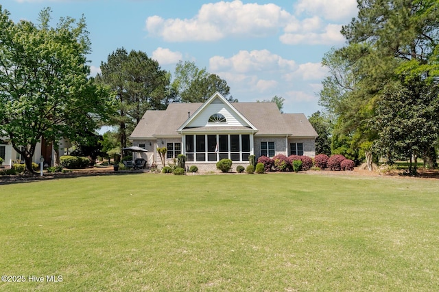 rear view of house featuring a sunroom and a lawn