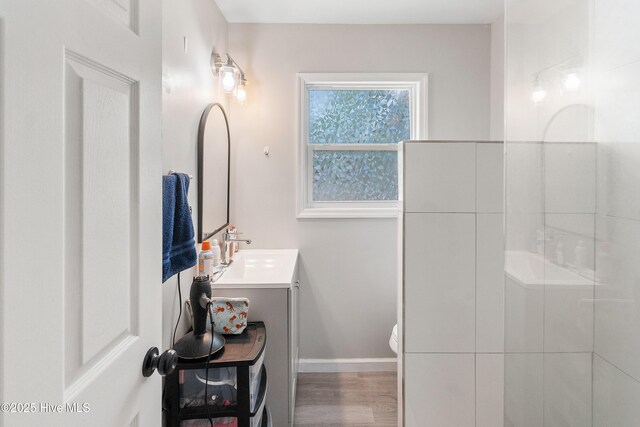 907 Bonham Ave, Wilmington, NC 28403 - bathroom featuring toilet, baseboards, walk in shower, wood finished floors, and vanity