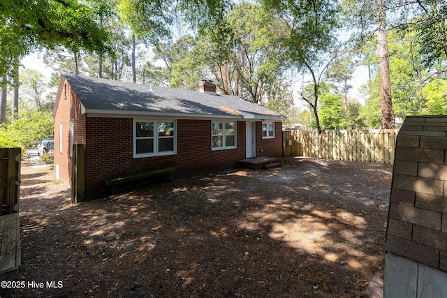 907 Bonham Ave, Wilmington, NC 28403 - rear view of house with fence, a chimney, and brick siding
