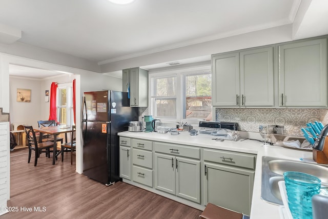 907 Bonham Ave, Wilmington, NC 28403 - kitchen featuring light countertops, wood finished floors, ornamental molding, freestanding refrigerator, and decorative backsplash