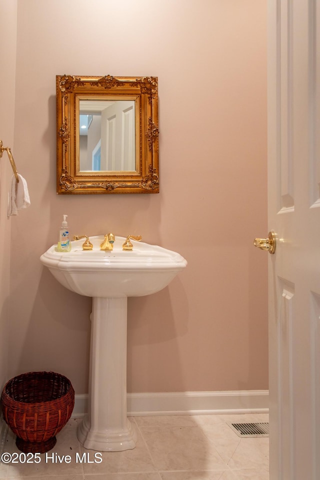 bathroom with a sink, visible vents, baseboards, and tile patterned flooring