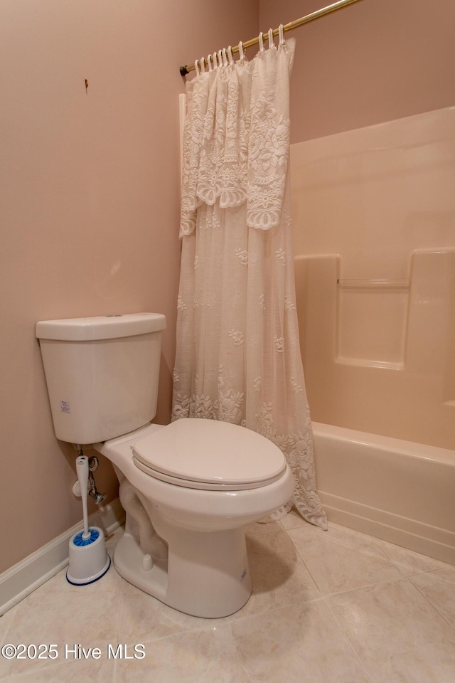 bathroom featuring tile patterned floors, shower / tub combo, and toilet