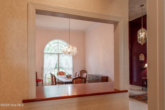 dining room featuring a chandelier, ornamental molding, and tile patterned flooring