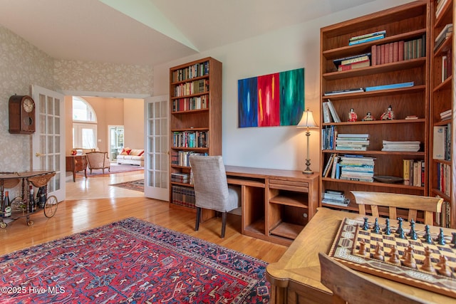 office space with french doors, wallpapered walls, and wood finished floors