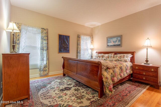bedroom with baseboards and wood finished floors