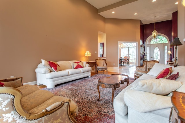 living area featuring recessed lighting, a towering ceiling, baseboards, and wood finished floors