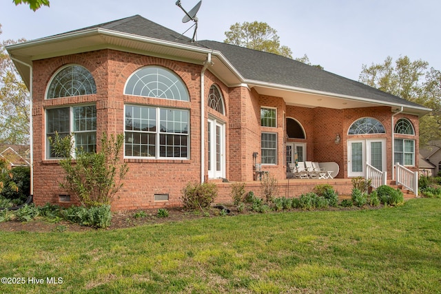 view of front facade with a front yard, brick siding, and crawl space