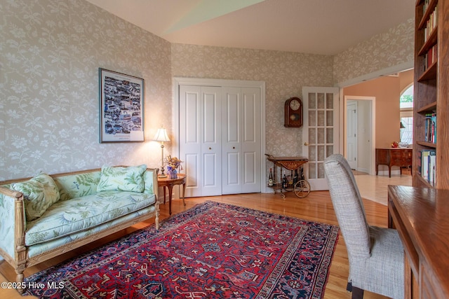 living area with wallpapered walls and wood finished floors