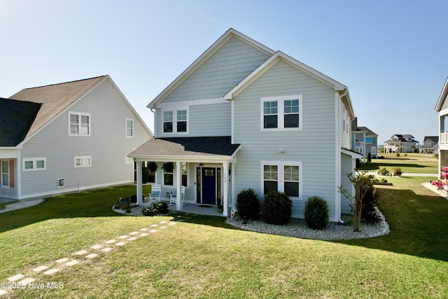 view of front of property with a porch, a shingled roof, and a front lawn