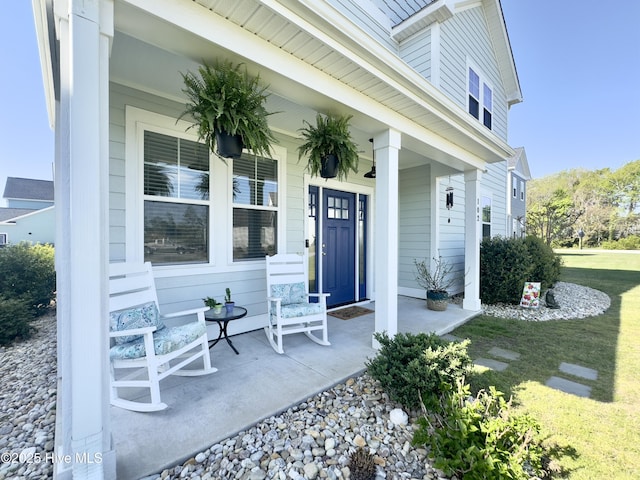 doorway to property with a yard and covered porch