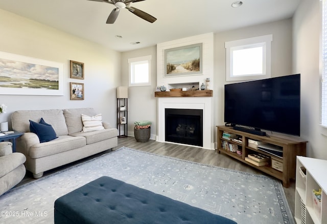 living room featuring wood finished floors, a ceiling fan, a fireplace, visible vents, and recessed lighting