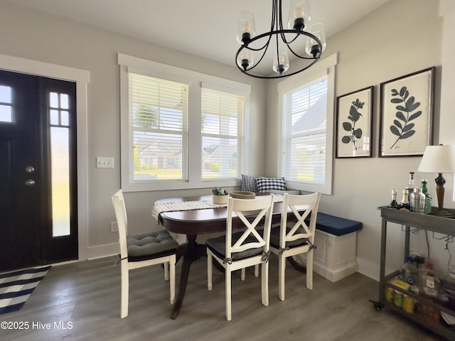 dining room with a wealth of natural light, a notable chandelier, and wood finished floors