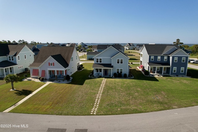 view of front of property with a front lawn, roof with shingles, and covered porch