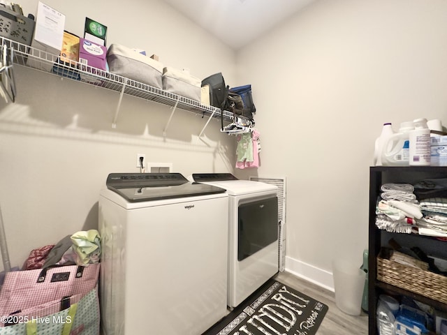 washroom featuring laundry area, independent washer and dryer, wood finished floors, and baseboards
