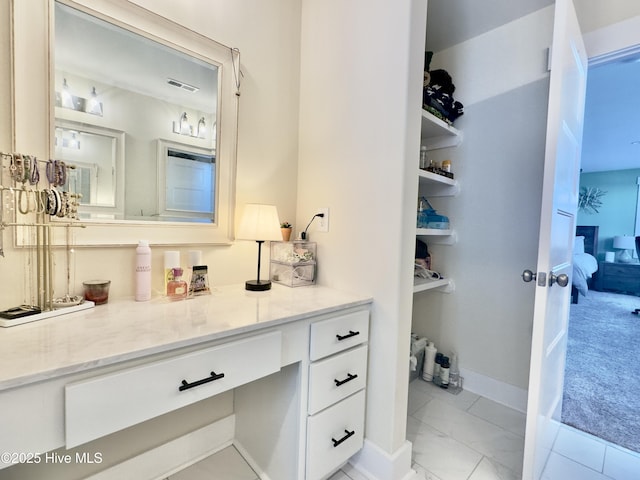 ensuite bathroom featuring baseboards, ensuite bathroom, vanity, and visible vents