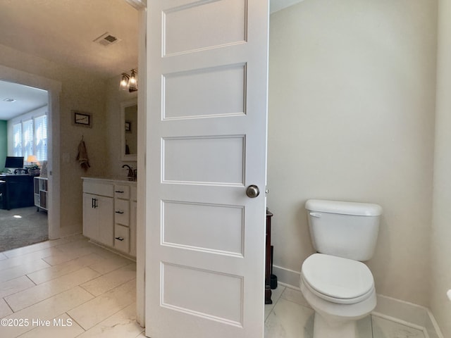 bathroom featuring toilet, visible vents, baseboards, and vanity