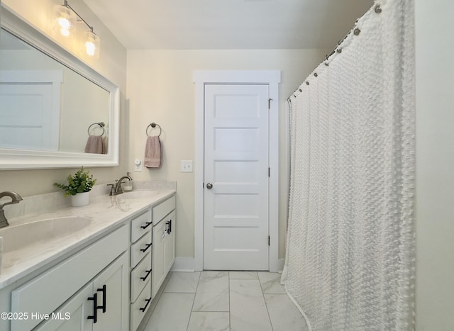 bathroom featuring double vanity, marble finish floor, and a sink