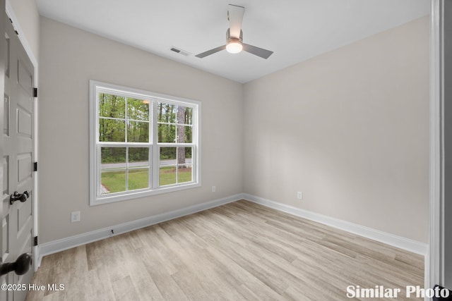 spare room featuring light wood-style flooring, baseboards, a ceiling fan, and visible vents