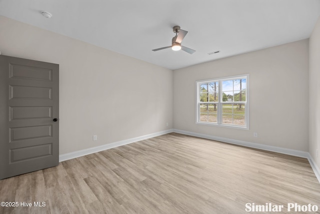 spare room with light wood-type flooring, ceiling fan, baseboards, and visible vents