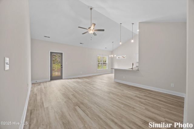 unfurnished living room with light wood-type flooring, ceiling fan with notable chandelier, baseboards, and visible vents