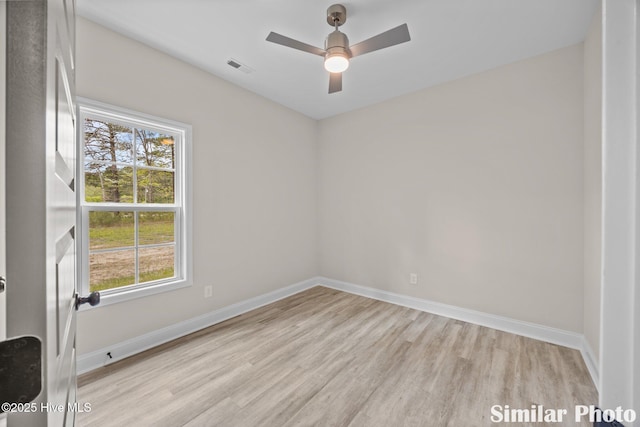spare room featuring plenty of natural light, light wood-type flooring, baseboards, and a ceiling fan