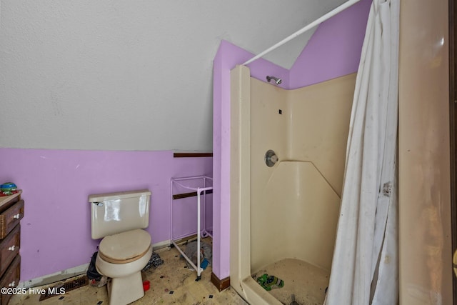 full bathroom with toilet, a stall shower, baseboards, and lofted ceiling