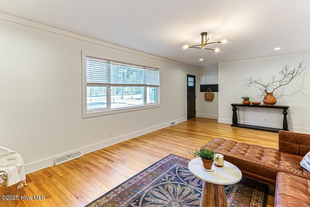 1369 Linden Rd, Aberdeen, NC 28315 - living room with a chandelier, wood finished floors, ornamental molding, and baseboards