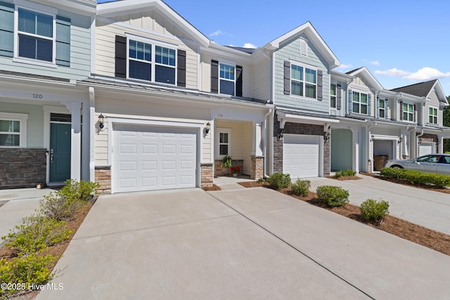 multi unit property featuring concrete driveway, board and batten siding, stone siding, and a garage