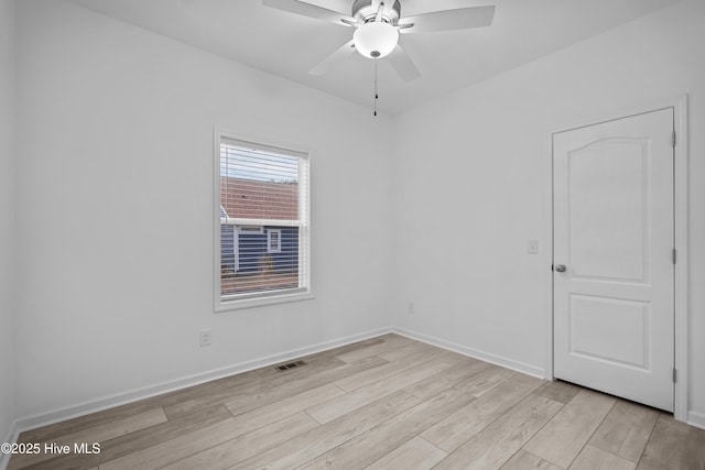 unfurnished room with visible vents, light wood-type flooring, baseboards, and ceiling fan