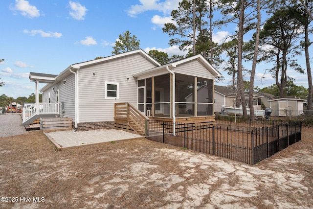 back of property featuring a patio area, fence, and a sunroom