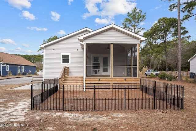 view of front of property with a sunroom, a fenced front yard, and a ceiling fan
