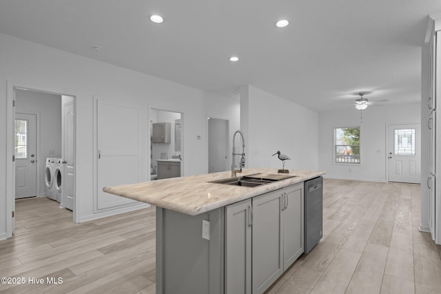kitchen featuring separate washer and dryer, gray cabinetry, ceiling fan, dishwasher, and a sink