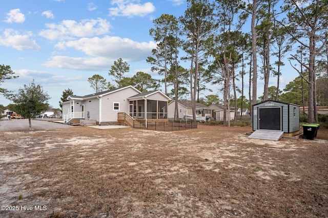 view of yard featuring a sunroom, an outbuilding, a shed, and fence