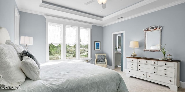 bedroom with light colored carpet, visible vents, a tray ceiling, and ornamental molding