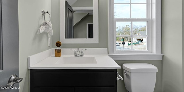 half bath featuring toilet and vanity