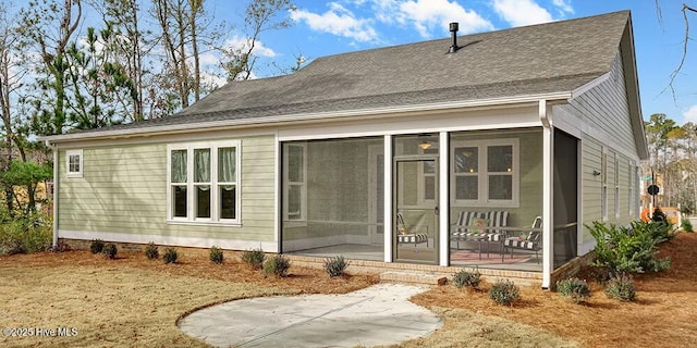 back of property with a sunroom and a shingled roof